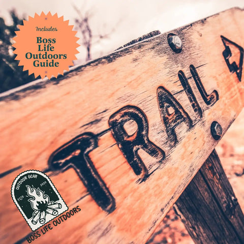 A wooden trail sign outdoors with Boss Life Outdoors Guide badge