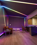 LED-lit room with Dotless RGB LED Strip Lights With Smart IC Addressable COB Tape 16.4ft outlining ceiling and walls, 24V.