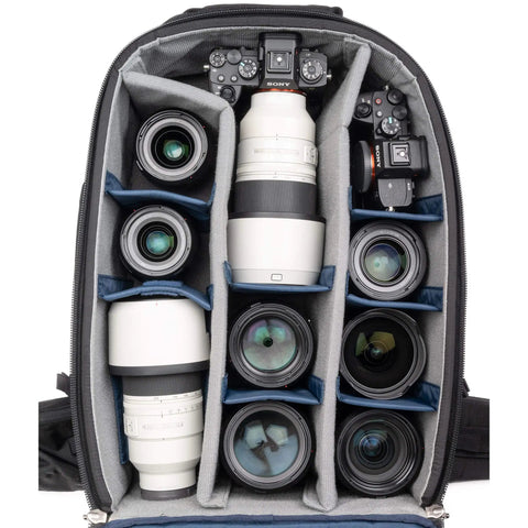 46L Camera Backpack For Travel Photography With Expandable Front Pocket For A 16 Inch Laptop And Gear Adjustable Foam Dividers 11 Point Harness Perfect For Telephoto Lenses And Adventure Trips inside view with camera gear and lenses arranged in compartments.