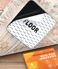 Rug corner showing No Slip Rug Corner Grips 4 Pcs For Hardwood Floors And Tile, with visible adhesive and packaging box.