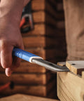 Using the 10 Inch Nail Puller Cats Paw Pry Bar With Magnetic Hammer Head Crowbar for prying baseboards in a woodwork setting.