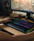Badass Gaming Keyboard Featuring Mechanical Membrane Keys Dope RGB Lighting with hand on keys during gameplay.