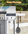 Side view of perforated aluminum pizza turning peel, dark gray, hanging from outdoor grill.