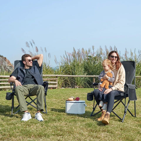People sitting in Oversized Folding Camping Chair For Outdoors, Built Tough Heavy Duty Quad Lawn Chair With Side Pockets in a grassy area.