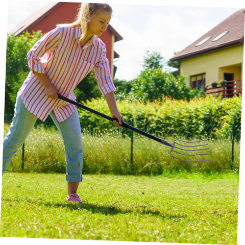 Person using Multi Functional Handheld Manure Fork For Quick Farmyard Cleanup And Lawn Maintenance With Sturdy Iron Construction