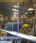 Purple Endless Round Lifting Sling 1 Inch By 12 Feet hoisting metal pipe in warehouse; synthetic yarn core, double wall polyester cover.