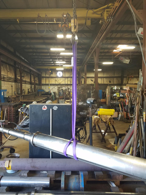 Purple Endless Round Lifting Sling 1 Inch By 12 Feet hoisting metal pipe in warehouse; synthetic yarn core, double wall polyester cover.