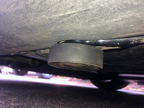Tesla Model 3 Y S X Lifting Jack Pads 4 Pack With Mesh Carry Bag shown under car, solid rubber pad at jacking point for maintenance.