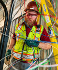 Electrician handling heavy duty building wire stranded copper 12 gauge 1 conductor 20 amp on job site with ladder and equipment.