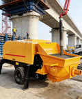 Heavy Duty Concrete Transfer Pump For Construction Sites Built Tough To Move Slurry Fast With Gate Valve, Delivery Equipment, And Custom Pipeline Extensions For Logistics Parks And Warehouse Projects Pro Grade. Yellow hopper pump at bridge site