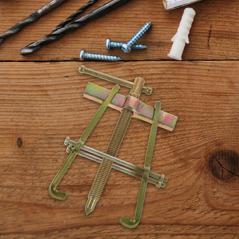 Heavy Duty Carbon Steel Two Jaw Gear Bearing Puller With Reinforced Grips on wooden surface, tools nearby, for mechanics.
