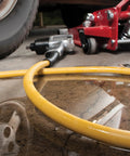 Oil Resistant Rubber Air Hose 3/8in x 50ft With 3/8in To 1/4in Reducer, 300 PSI Max, Yellow shown on workshop floor