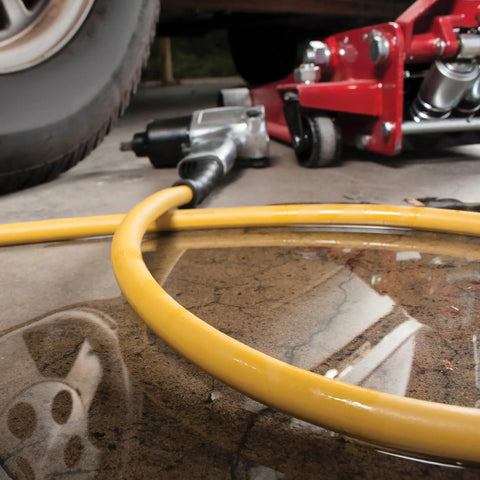 Oil Resistant Rubber Air Hose 3/8in x 50ft With 3/8in To 1/4in Reducer, 300 PSI Max, Yellow shown on workshop floor