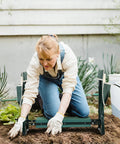 Woman using Garden Kneeler And Seat Foldable Stool With Thick EVA Pad And Dual Tool Pouches for gardening tasks in green.