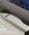 Six Outlet Surge Protector Power Strip With A 2 Ft Cord, 450 Joules Surge Protection, shown on a corner table in home setting