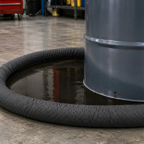Heavy Duty Universal Absorbent Socks 12 Plus Pack Spill Containment Tubes around a barrel catching liquid spills in a garage.
