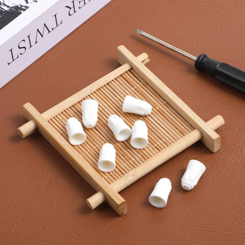 Front view of white ceramic wire connectors (porcelain caps) on a small bamboo tray with a screwdriver.