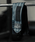 18 Inch Heavy Duty Wrist Wraps For Weightlifting And Powerlifting With Ultra Strong Support For Bench Press, Deadlifts, Curls, CrossFit, And General Gym Workouts For Men hanging on a barbell in a gym setting