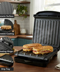 Ovente Two Serving Electric Indoor Grill And Panini Press Compact Contact Maker For Juicy Steaks Bold Smoky Flavor No Outdoor Mess Black Kitchen Appliance with grilled sandwiches and ceramic surface.