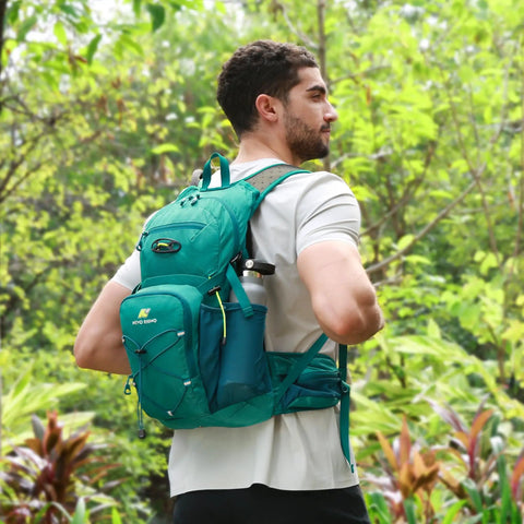 Man wearing Hydration Backpack With 3L Water Bladder, 18L Multipurpose Hiking Pack For Outdoors in green hiking in forest