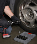Man using Damaged Lug Nut Flip Socket Set With Half Inch Drive And Three Inch Extension on car wheel, socket set visible.