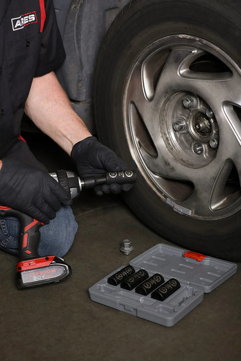 Man using Damaged Lug Nut Flip Socket Set With Half Inch Drive And Three Inch Extension on car wheel, socket set visible.