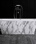 Marble-patterned bathtub with modern fixtures against dark wall
