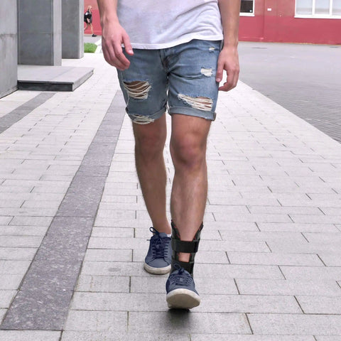 Man walking on street wearing All Day Ankle Stabilizer Brace With Stirrup Support For Foot Injuries Tendonitis And Chronic Ankle Instability