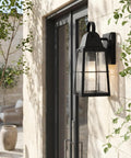 Tolerand 12 Inch Outdoor Wall Light In Textured Black With Clear Seeded Glass 1 Light Exterior Sconce mounted on stone wall