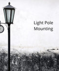 Black street lamp with clock on a concrete wall background displaying the text 'Light Pole Mounting'.
