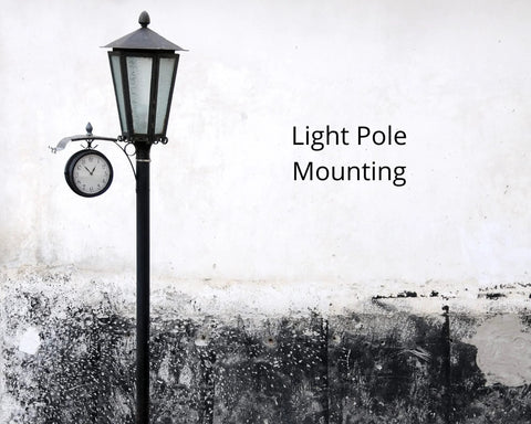 Black street lamp with clock on a concrete wall background displaying the text 'Light Pole Mounting'.