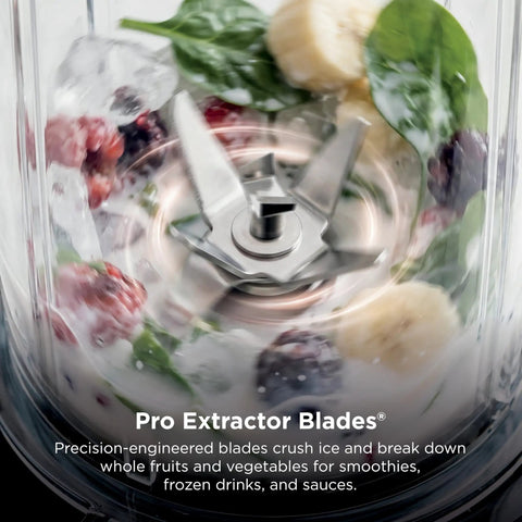 Heavy Duty Personal Blender Featuring 900W Push To Blend Motor And Pro Extractor Blades Crushing Ice For Nutrient Dense Smoothies Including Three Grab And Go 20 Oz Serveware Cups In Classic Silver - close-up of Pro Extractor Blades in action.