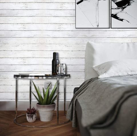 Bedroom with 590 In By 17.7 In White Wood Peel And Stick Wallpaper Removable Vintage Wood Plank Wall Covering behind bed and table.