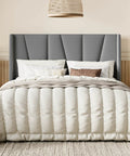 Flat Out Comfy Queen Size Upholstered Platform Bed Frame With Wingback Headboard And High Density Foam Padding Wrapped In Soft Breathable Velvet Fabric For Stylish Grey Rooms in a bedroom with white bedding.