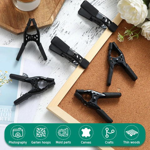 Kickass Heavy Duty Spring Clamps A Twenty Four Pack Delivering Snug One Point Five Inch Openings And Secure Non Slip Handles All Black Tooling on cork board.