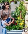 Mother and daughter tending plants in Galvanized Raised Garden Bed With Legs 48 By 24 By 32 Inch Elevated Planter Box With Drainage Holes