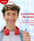 Teen with braces using soft pick from Max Fresh Wisp Disposable Mini Travel Toothbrushes Peppermint Pack Of 24 No Water Needed