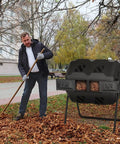 Man raking leaves near Dual Chamber Tumbling Composter With 43 Gallon Capacity 360 Degree Spin BPA Free Garden Tumbling Bin