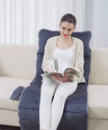 Woman sitting on Full Body Massage Mat With Heat And 10 Vibrating Motors Memory Foam Pad, reading on couch, home spa vibe