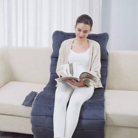 Woman sitting on Full Body Massage Mat With Heat And 10 Vibrating Motors Memory Foam Pad, reading on couch, home spa vibe