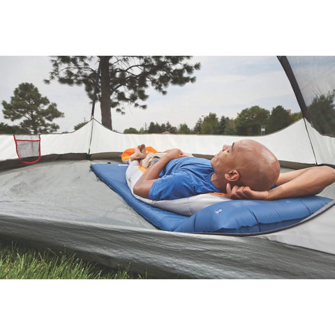 Man lying on self-inflating sleeping pad with pillow for camping, lightweight portable camp pad with extra support and quick deflation
