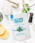 Muscle Recovery Epsom Salt Soak With Eucalyptus And Peppermint Essential Oils, 12 Lbs Total, Six Two Pound Bags shown with bath items.