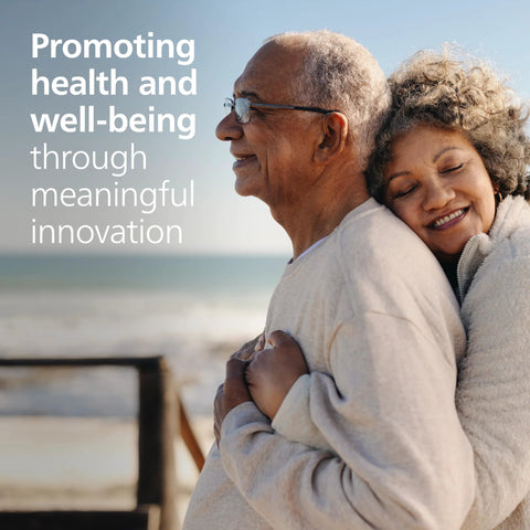 Philips HeartStart Home AED Defibrillator, Value Package: older couple embracing on a beach; beige clothing.