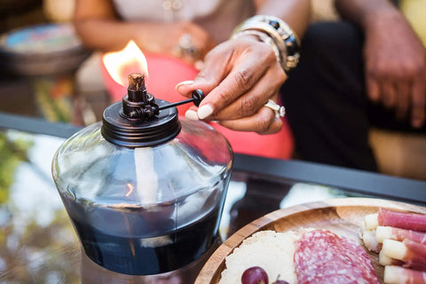 Person adjusting 6.25 Inch Adjustable Flame Penta Glass Votive Tabletop Torch For Cozy Patio Vibes Watercolor Blue Outdoor Lighting
