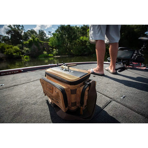 Guide Series 3500 Soft Tackle Bag With Five 3500 Stowaway Boxes, khaki color, on boat deck next to standing person, scenic background