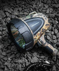 Hunting Spotlight 1500 Lumen Camouflage Handheld Corded 12V Spotlight With Realtree Xtra Print resting on rocky ground