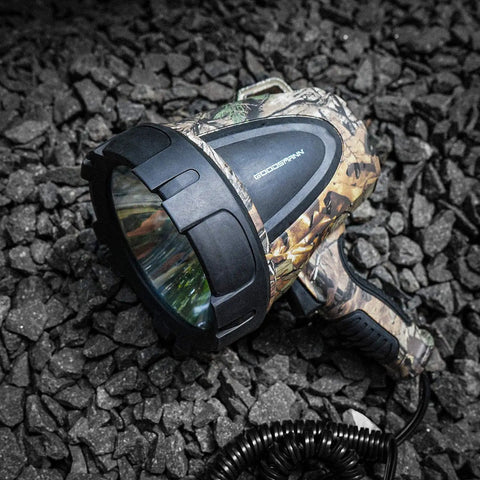 Hunting Spotlight 1500 Lumen Camouflage Handheld Corded 12V Spotlight With Realtree Xtra Print resting on rocky ground