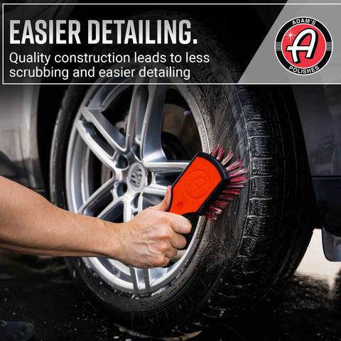 Hand using Premium Tire Brush For Car Detailing And Tire Cleaning With Soft Bristles Rubberized Head And Grippy Handle