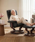 Woman relaxing on manual recliner with ottoman for RV and small spaces 360 degree swivel black faux leather with dual side recline knobs