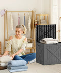36 Gallon Outdoor Deck Box Waterproof Lockable Resin Storage Chest in use, with towels in a home setting beside a woman folding clothes.